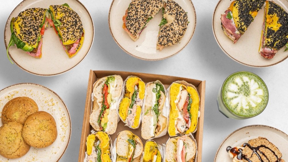 Bagel-Box, halbierte Bagel-Sandwiches und Getränke auf dem Tisch